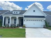 Charming two-story home featuring a modern farmhouse design and well-maintained landscaping at 324 Basil Dr, Indian Trail, NC 28079