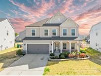 Charming two-story home featuring a two-car garage, landscaped yard, and covered front porch at 7314 Rupell Dr, Charlotte, NC 28273