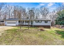 Charming single-story home with a front porch and attached garage, offering classic curb appeal at 1140 Knollwood Dr, Claremont, NC 28610