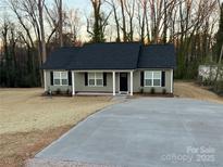 Charming single-story home with a well-maintained lawn and a long concrete driveway leading to the front entrance at 1311 Meadow Ave, Kannapolis, NC 28083