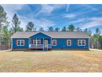 Charming blue home with a welcoming front porch, wood shutters, and well-maintained lawn at 1370 Martin Rd, Hickory Grove, SC 29717