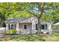Charming single-story home featuring a well-manicured lawn, mature tree, and quaint front porch at 1509 Harrill St, Charlotte, NC 28205