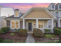 Charming home featuring stone accents, a covered porch, and manicured landscaping at dusk at 4108 Twenty Grand Dr, Indian Trail, NC 28079