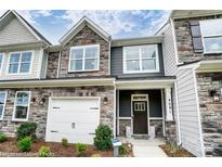 New townhome featuring stone accents, a one-car garage and a covered front entry at 4223 Black Ct # 195, Harrisburg, NC 28075