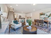 Bright, open-concept living room featuring modern furnishings and hardwood floors at 4235 Black Ct # 197, Harrisburg, NC 28075