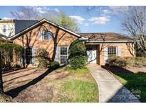 Charming single-story brick home with mature landscaping, a walkway, and a welcoming entrance at 4309 Woodglen Ln, Charlotte, NC 28226