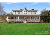 Charming two-story home with a sprawling front porch, perfect for relaxing and enjoying the outdoors at 534 Stewart Rock Rd, Stony Point, NC 28678