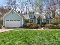 Charming home with a blue exterior, well-manicured lawn, and attached two-car garage at 800 Water Wheel Ct, Charlotte, NC 28209