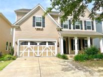 Charming two-story home featuring a decorative garage, black shutters, and a manicured front yard at 1007 Equipoise Dr, Indian Trail, NC 28079