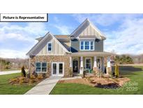 Charming two-story home with stone accents, inviting front porch, and well-maintained landscaping at 1010 Merganser Way, Indian Trail, NC 28079