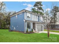 Two-story home featuring light blue siding, stone accents, and a well-manicured lawn at 2969 Beech Nut Rd, Charlotte, NC 28208