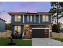 Charming two-story home features a modern design, stone accents, and a black garage door at 2969 Beech Nut Rd, Charlotte, NC 28208