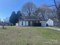 Charming single story house with a brick chimney and mature trees in the front yard at 3701 Teaberry Ct, Charlotte, NC 28227