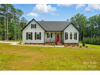 Charming single-story home with a red front door, black shutters, and a well-manicured lawn at 409 Henry Chapel Rd, Belmont, NC 28012