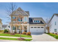 Charming two-story home with a well-manicured lawn, a covered front porch, and an attached two-car garage at 4219 Huntley Glen Dr, Pineville, NC 28134