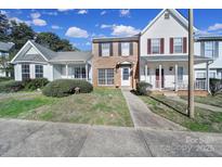 Traditional brick two-story townhome with a well-manicured front yard and inviting entrance at 6310 Windsor Gate Ln # 15, Charlotte, NC 28215