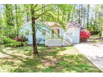 Charming light blue home featuring a cozy front porch and manicured lawn at 6628 Cool Water Ct, Charlotte, NC 28215