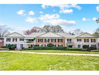 Charming brick and siding townhome with a well-manicured lawn and blue sky at 7213 Quail Meadow Ln, Charlotte, NC 28210