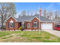 Charming one-story brick home with well-manicured lawn, American flag, and attached two-car garage at 801 Toncin Ave, Bessemer City, NC 28016