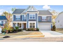Charming two-story home featuring a well-manicured lawn, attached garage, and inviting curb appeal at 967 Stebbins Dr, Fort Mill, SC 29715
