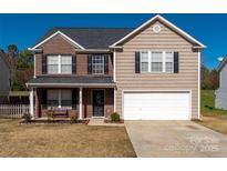 Charming two-story home featuring a brick facade, attached two-car garage and manicured front lawn at 1017 Village Green Ln, Rock Hill, SC 29730