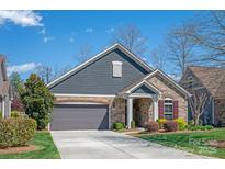 Charming home features a gray facade, stone accents, and a well-manicured lawn at 1128 Avalon Pl, Matthews, NC 28104
