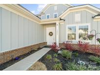 Close-up of the home's entrance, highlighting the wreath-adorned door, address number, and well-maintained landscaping at 14235 Canemeadow Dr, Charlotte, NC 28278
