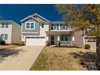 Charming two-story home with a well-manicured lawn and a welcoming front porch at 1519 Arcadia Bluff Dr, York, SC 29745