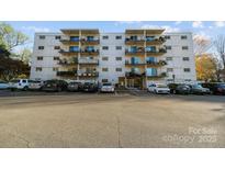 Multi-level condo building featuring private balconies and a well-maintained parking lot at 2503 Roswell Ave # 208, Charlotte, NC 28209