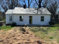 Charming single-story home with white siding and a metal roof, surrounded by a yard needing some TLC at 340 Grice St, Shelby, NC 28150