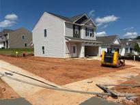 New construction home with a two-car garage, light gray siding, and an unfinished front yard at 5626 Skinny Dr, Charlotte, NC 28215