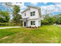 Charming two-story home featuring a crisp white exterior, black accents, and a well-manicured lawn at 600 Legrand St, Shelby, NC 28150