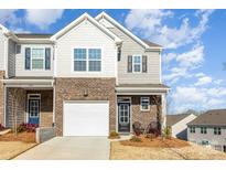 Inviting brick townhome featuring a one-car garage, covered porch, and charming exterior design at 6048 Chelsea Oaks Rdg, Tega Cay, SC 29708