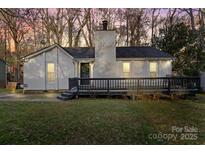 Charming exterior with a cozy front porch and white siding, surrounded by mature trees at 8220 Terra Linda Ln, Charlotte, NC 28215