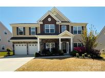 Charming two-story home with stone accents, manicured lawn, and a two-car garage at 9895 Travertine Trl, Davidson, NC 28036