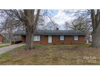 Charming single-story brick home with blue shutters and mature trees in a residential neighborhood at 103 Perry St, Shelby, NC 28150