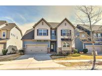 Beautiful two-story home featuring blue and white siding, stone accents, and an attached two-car garage at 1036 Easley St, Waxhaw, NC 28173