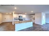 Open kitchen boasts white cabinets, granite countertops, a large island, and stainless steel appliances at 1059 Horizon St, Chester, SC 29706