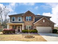 Charming two-story brick home with landscaped front yard and attached two-car garage at 13240 Carolina Wren Ct, Charlotte, NC 28278