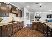 Modern kitchen featuring granite countertops, dark wood cabinetry, and stainless steel appliances at 13240 Carolina Wren Ct, Charlotte, NC 28278