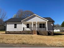 Charming single-story home featuring a classic covered front porch and neatly landscaped yard at 2037 Powerline Dr, Gastonia, NC 28054
