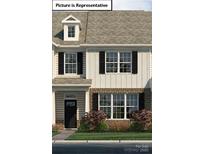 Charming two-story townhome featuring black shutters and a well-maintained landscaped front yard at 2056 Harlequin Dr, Indian Trail, NC 28079
