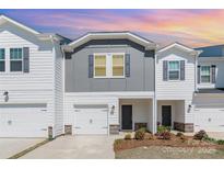 Inviting exterior view of the townhome featuring a one car garage and manicured landscaping at sunset at 3870 County Down Ave, Kannapolis, NC 28081