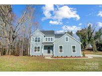 Two-story home with light blue siding, black front door, white framed windows, and a freshly mowed lawn at 522 Fern Hill Rd # 17, Mooresville, NC 28117