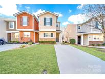 Charming townhome featuring colorful facades, a well-manicured lawn, and a private driveway at 746 Elders Story Rd, Fort Mill, SC 29708