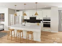 Bright kitchen features an island with seating, modern appliances, and stylish pendant lighting at 8034 Cedarsmith Ct, Charlotte, NC 28217