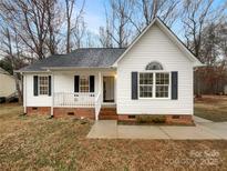 Charming one-story home with white siding, black shutters, covered front porch, and well-maintained landscaping at 89 Fifth St, York, SC 29745