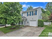 Charming two-story home featuring blue shutters and a well-maintained front yard with mature trees at 1017 Chalk Hill Ln, Charlotte, NC 28214