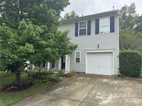 Two-story home with vinyl siding, blue shutters, a single-car garage, and mature landscaping at 1017 Chalk Hill Ln, Charlotte, NC 28214