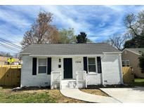 Charming, newly renovated single story home featuring freshly painted white brick exterior, black shutters, and a walkway to the front door at 1946 Academy St, Charlotte, NC 28205